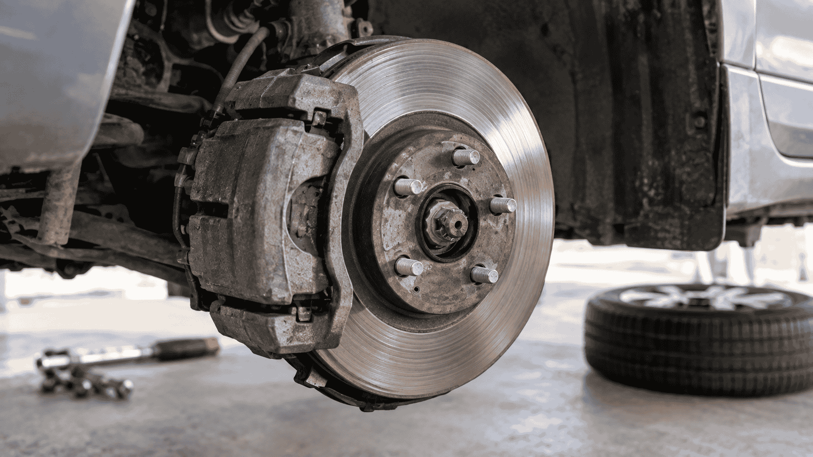 Car brake rotor and worn brake pads showing grinding damage